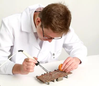 Working electronics repairing board using soldering pen Stock Photos