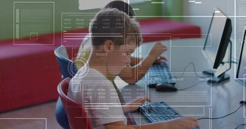 Working elementary students typing code on desktop monitors in coding lab, wi Foto stock