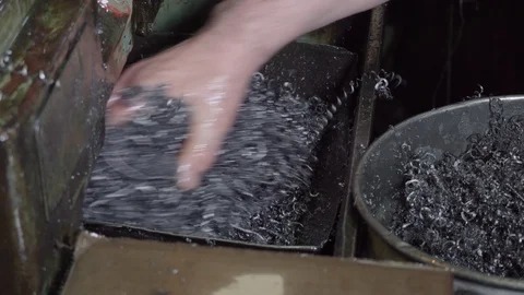 Working engineer in the factory, removes metal shavings with his hands from the Video stock 116809239