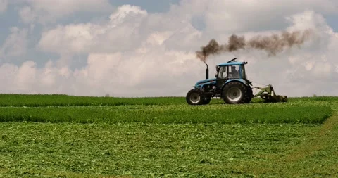 Working on a farm field -- mowing Stock Footage 89440220