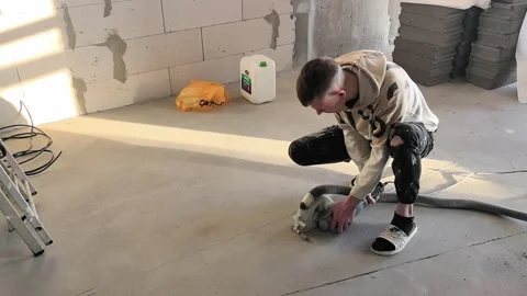 Working on floor preparation in construction site during the afternoon with tool Stock-Footage 332132653