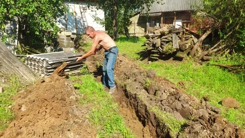 Working on a garden project in the backyard with shovel digging in the sunny aft Vídeo Stock 329824347