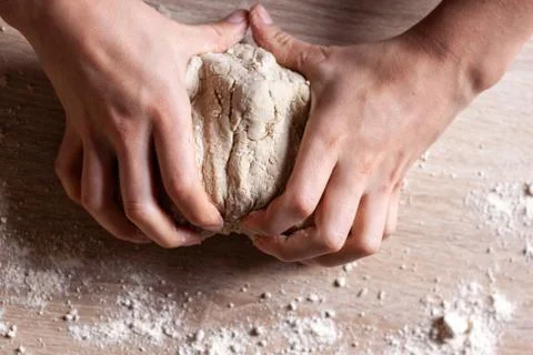 Working hands kneading bread dough. Wooden background Stock Photos