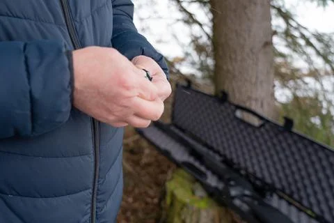 Working hands load bullets into the clip, preparing for target shooting. Hand Foto stock