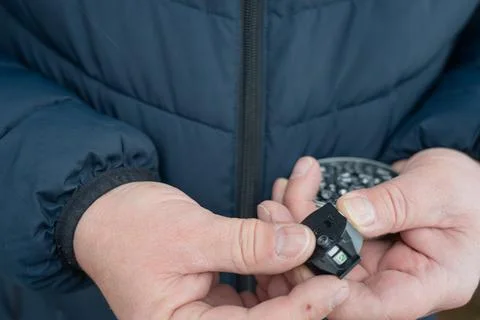 Working hands load bullets into the clip, preparing for target shooting. Hand Stock Photos
