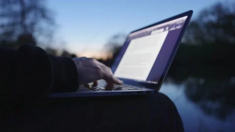 Working hands on Notebook in nature at sunset computer typing river 스톡 동영상 232029414