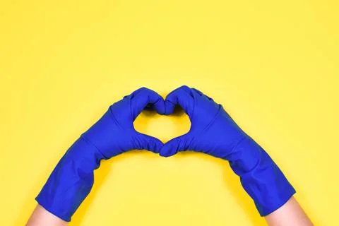 Working hands in rubber protective gloves show the heart. Stock Photos
