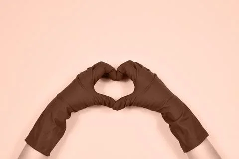 Working hands in rubber protective gloves show the heart. Stock Photos