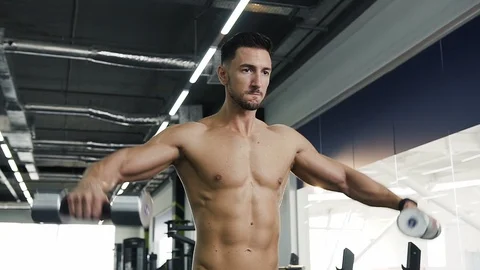 Working hard fit guy with nake torso doing exercises for hands using dumbbells. Vídeos de archivo 99209370