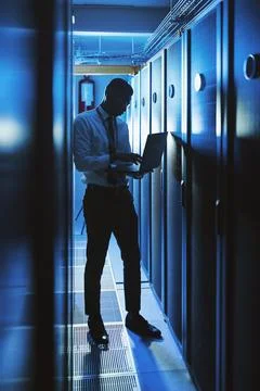Working hard to keep your information safe. a young man working in an IT server Stock-Fotos
