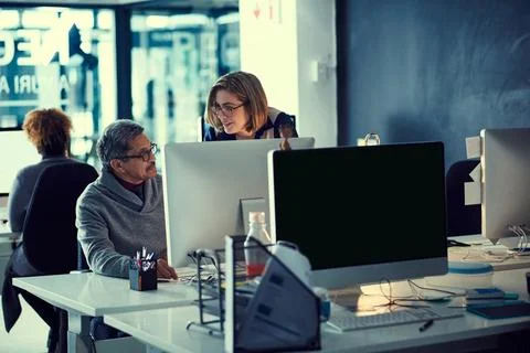 Working hard to knockout their deadlines. a group of businesspeople working late Stock Photos