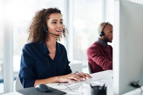 Working hard to solve your problems. an attractive young female call center Stock Photos