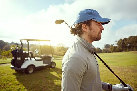 Working on his game. a focused looking young man playing golf. Stockfoto's