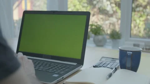 Working from home in the conservatory using the trackpad mouse on a green sc Stockbeeldmateriaal 133806392