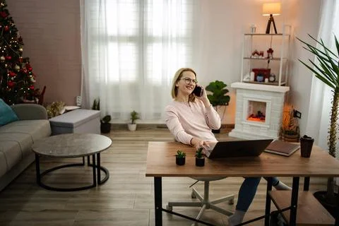 Working from home in a cozy winter setting with holiday decorations and a warm Stock Photos
