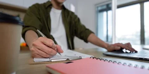 Working from Home. Creative Professional Taking Notes and Using Laptop Stock-Fotos
