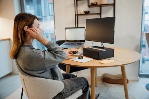 Working from home at a desk with a computer and phone in a modern apartment Stock Photos