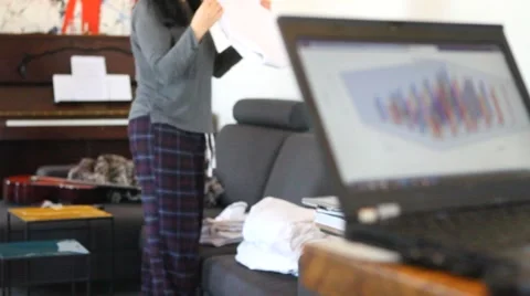 Working from home folding laundry and laptop2 Stock-Footage 60652004