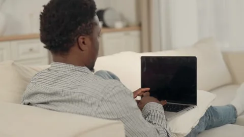 Working in home office, remote employee with laptop sitting on couch in room Stock Footage 282959936