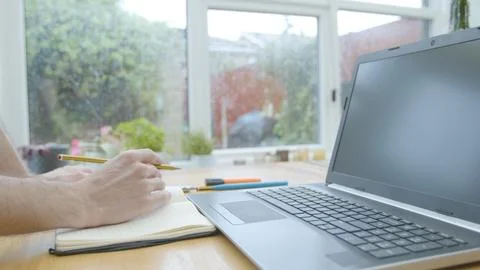Working from home using a laptop on the dinner table Foto stock