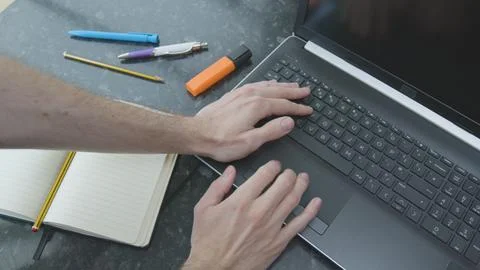 Working from home using a laptop on the dinner table Foto stock