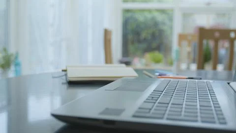 Working from home using a laptop on the dinner table Foto stock