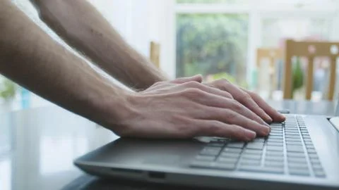 Working from home using a laptop on the dinner table Foto stock