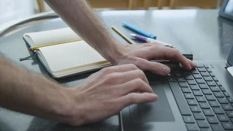 Working from home using a laptop on the dinner table Foto stock
