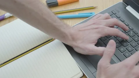 Working from home using a laptop typing fast on the dinner table in close up Stockbeeldmateriaal 133809154