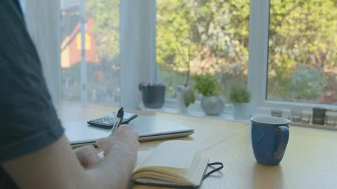 Working from home using a notepad on the dinner table Foto stock