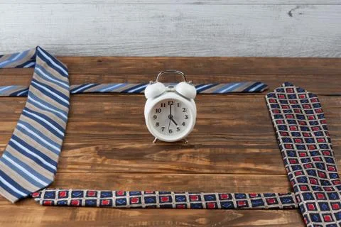 Working hours day concept. Ties and vintage alarm clock. Stock Photos