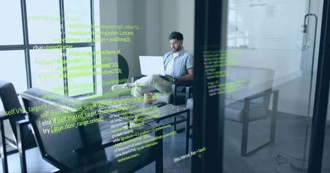 Working Indian software engineer coding on laptop on sofa in office lounge with Stock Photos