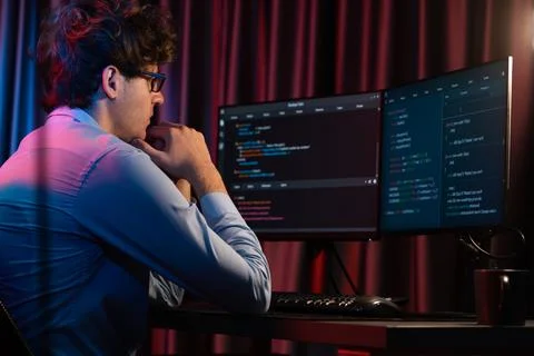 Working IT developer concentrating online software at neon light room. Gusher. 스톡 사진