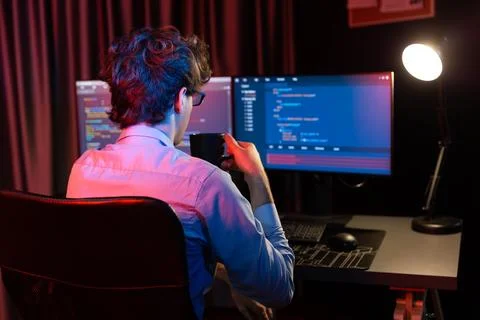 Working IT developer concentrating online software at neon light room. Gusher. Foto stock