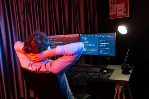 Working IT developer concentrating online software at neon light room. Gusher. 스톡 사진