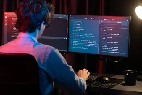 Working IT developer concentrating online software at neon light room. Gusher. 스톡 사진