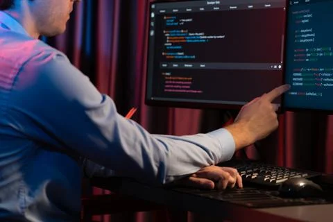 Working IT developer concentrating online software at neon light room. Gusher. Stock Photos