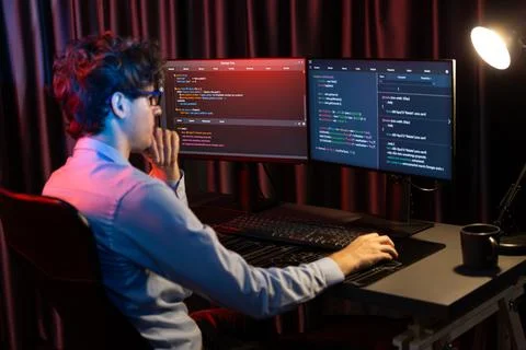 Working IT developer concentrating online software at neon light room. Gusher. 스톡 사진
