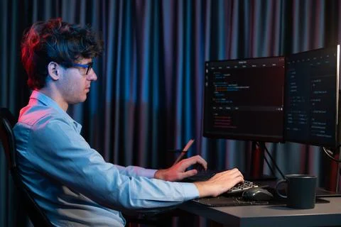 Working IT developer concentrating online software at neon light room. Gusher. 스톡 사진