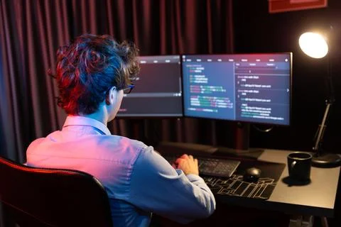 Working IT developer concentrating online software at neon light room. Gusher. Stockfoto's