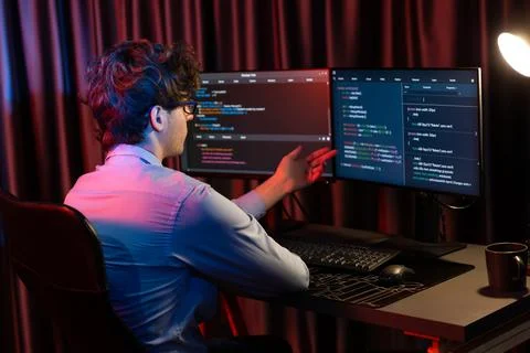 Working IT developer concentrating online software at neon light room. Gusher. 스톡 사진