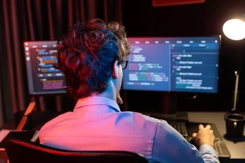 Working IT developer concentrating online software at neon light room. Gusher. Foto stock