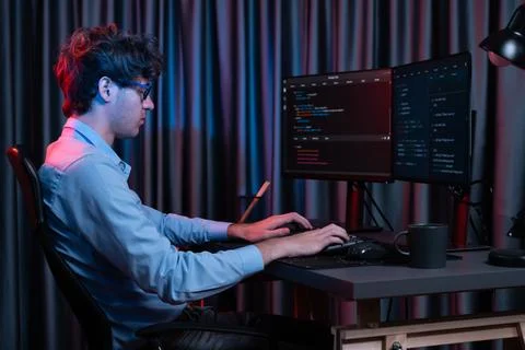 Working IT developer concentrating online software at neon light room. Gusher. Foto stock