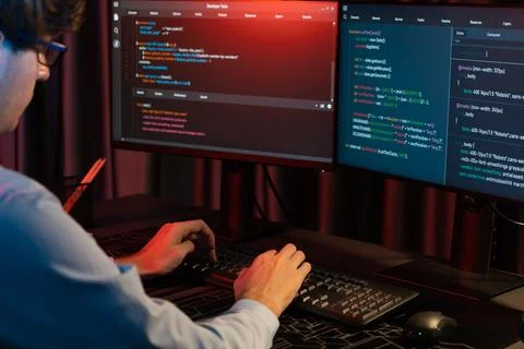 Working IT developer concentrating online software at neon light room. Gusher. Foto stock
