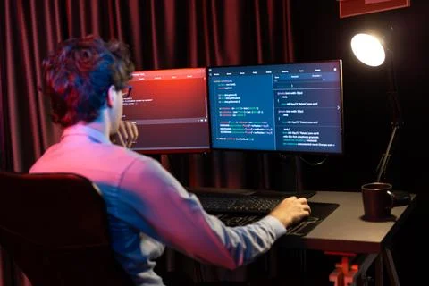 Working IT developer concentrating online software at neon light room. Gusher. 스톡 사진