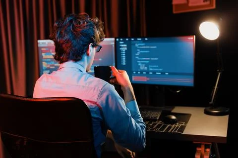 Working IT developer concentrating online software at neon light room. Gusher. 스톡 사진