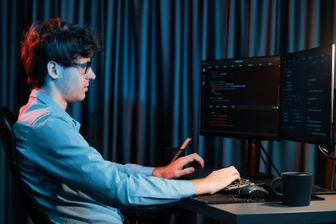 Working IT developer concentrating online software at neon light room. Gusher. Stockfoto's