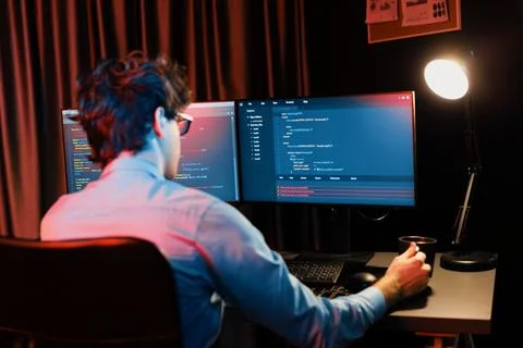 Working IT developer concentrating online software at neon light room. Gusher. Foto stock