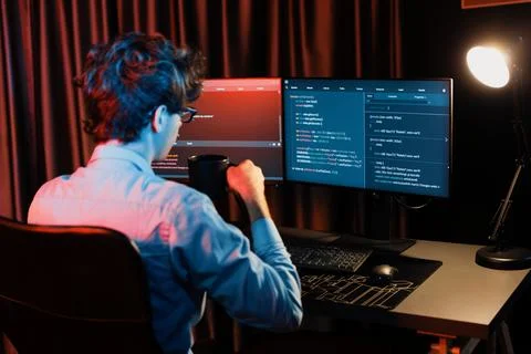 Working IT developer concentrating online software at neon light room. Gusher. Stockfoto's