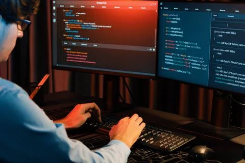Working IT developer concentrating online software at neon light room. Gusher. Stockfoto's